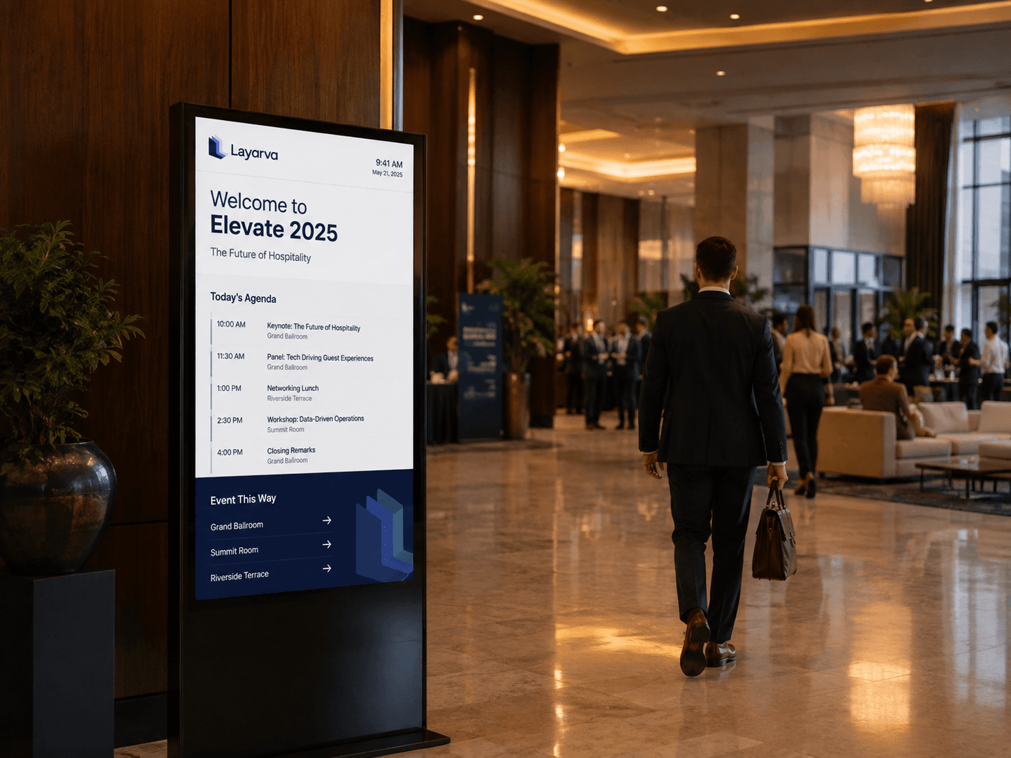 Event venue with a large screen showing the day's programme to arriving guests